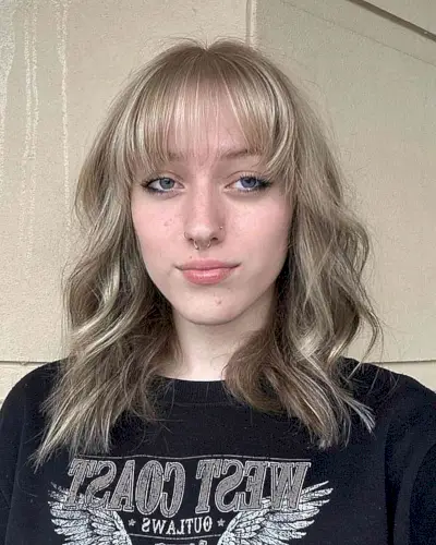 Shoulder-Length Glossy Ash Blonde Balayage Waves with Barely-There Bangs