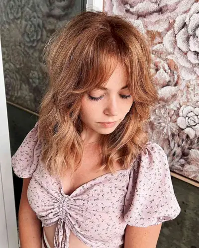 Mid-Length Wavy Strawberry Balayage Hair with Curtain Bangs