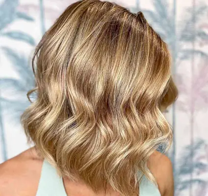 Shoulder-Length Wavy Bob with Warm Butterscotch Blonde Balayage Highlights