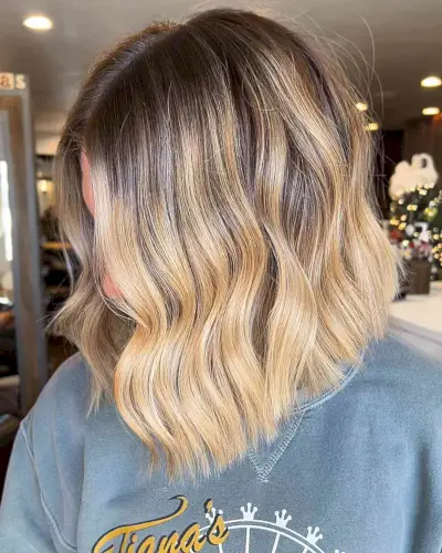 Low-Maintenance Sandy Warm Blonde Balayage with Dark Roots on Shoulder-Length Bob