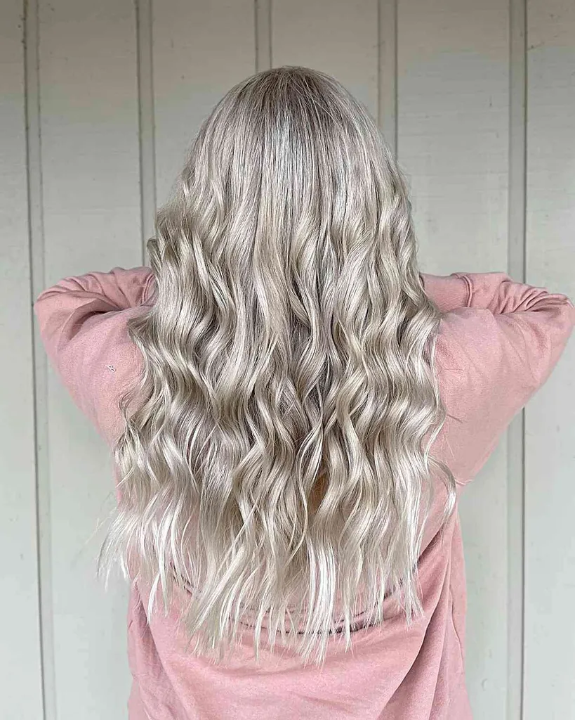 Langes, eisiges, platinblondes Haar mit lockeren Locken' title=