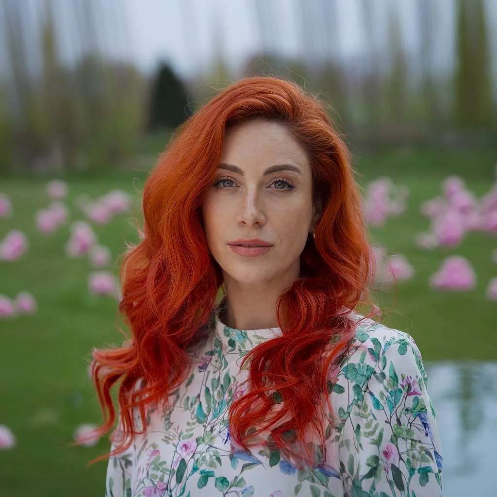 부드러운 웨이브를 더해 생동감 있고 대담한 봄 헤어 컬러를 연출하는 중간 밝은 구릿빛 레드 헤어' title=