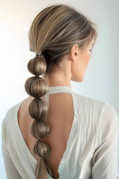 長く汚れたブロンドのバブル ポニーテール、後ろから。