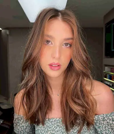 Voluminous Wavy Hairstyle with Warm Tones for Long Faces