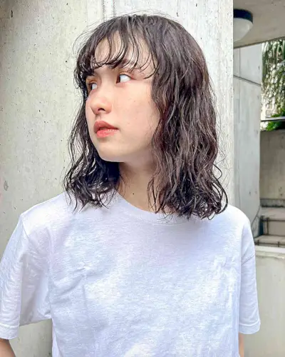 Shoulder-Length Perm Body Waves with Wispy Bangs