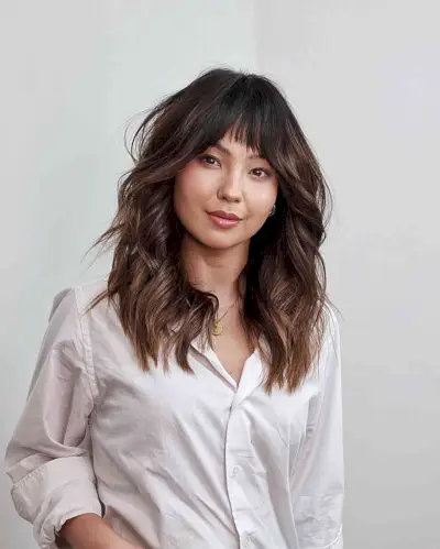 Feminine Mid-Length Loose Waves with Bangs for a Heart Face