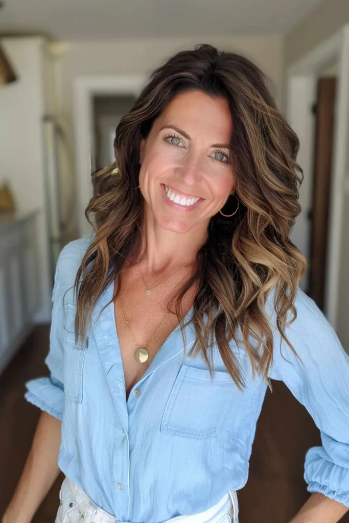 Femme avec un balayage brune moyenne et des vagues douces' title=