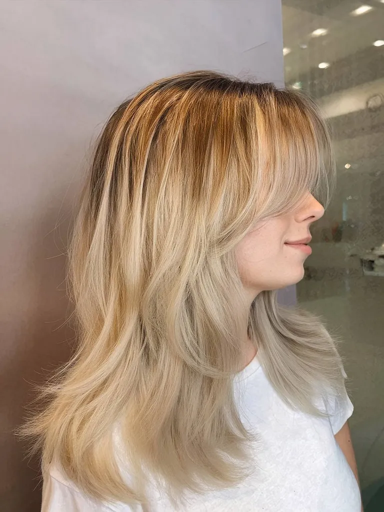 Prosta fryzura inspirowana latami 90. z blond pasemkami i grzywką z zasłony' title=