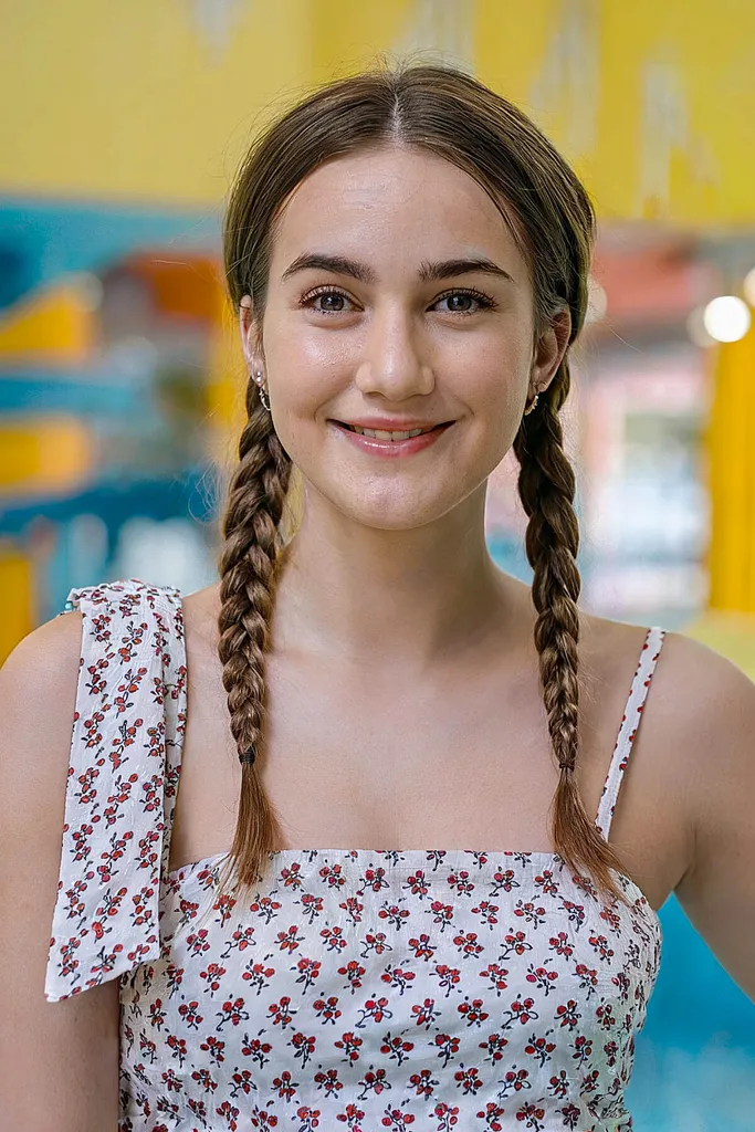 Uma mulher com divertidas tranças de verão, ideais para cabelos de comprimento médio e fáceis de manusear para um dia no parque aquático' title=