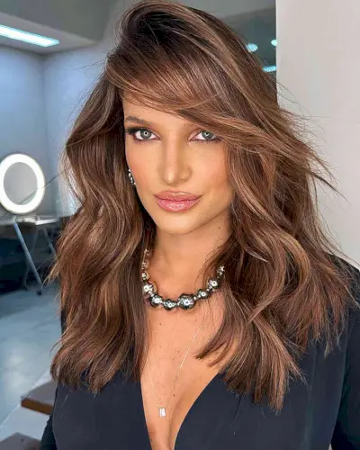 Long Brown Balayage Hair with a Deep Side Part and sweeping bangs