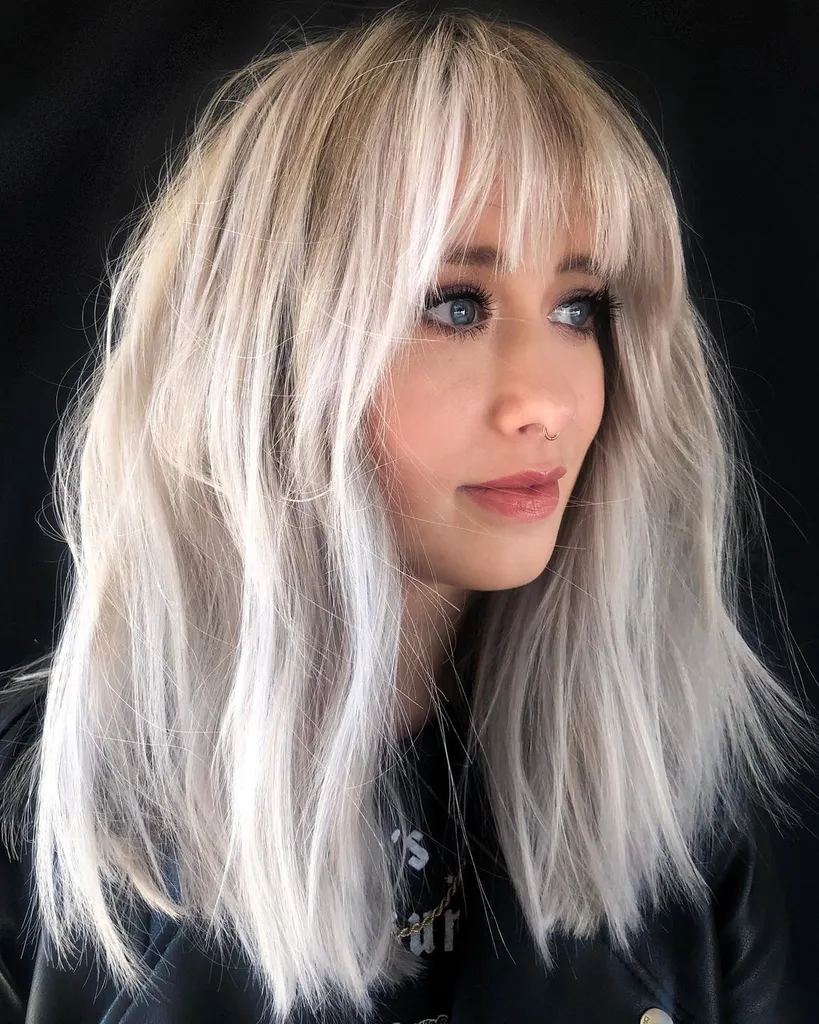 taglio mosso di media lunghezza con frangia' title=