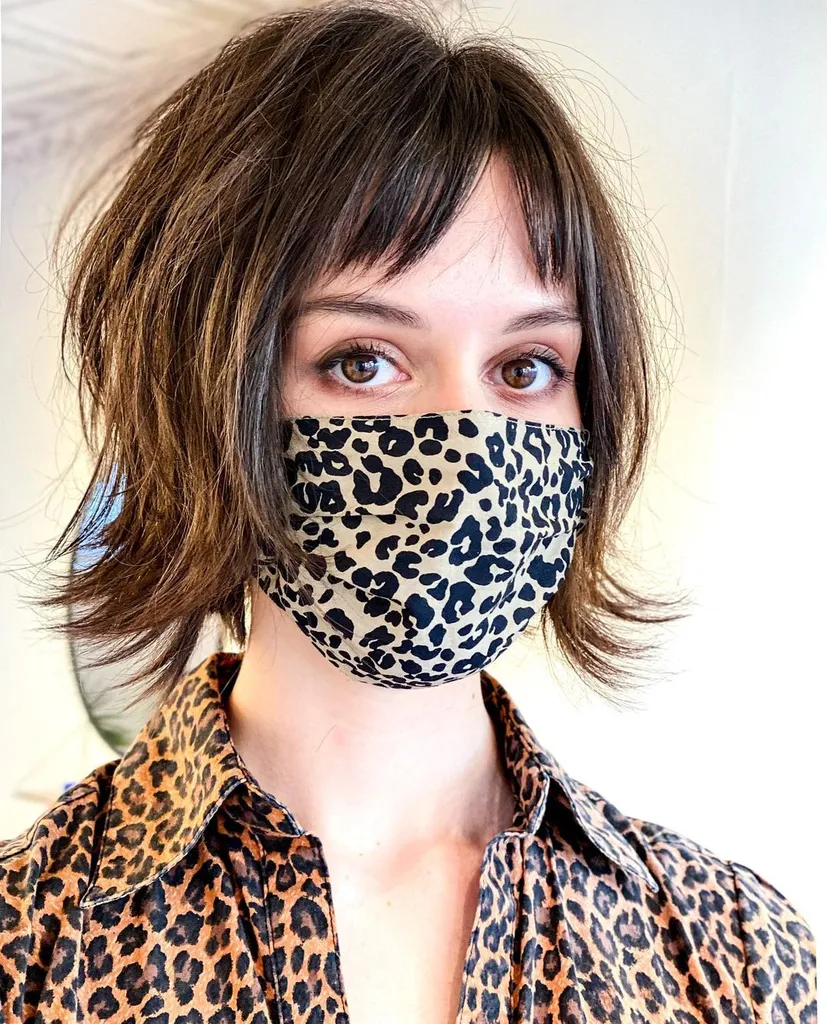 Bob tagliato a strati con frangia divisa' title=