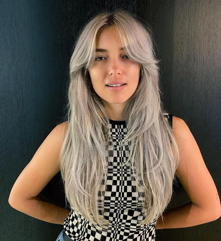 Taglio di capelli arruffato anni '70 su capelli lunghi' title=