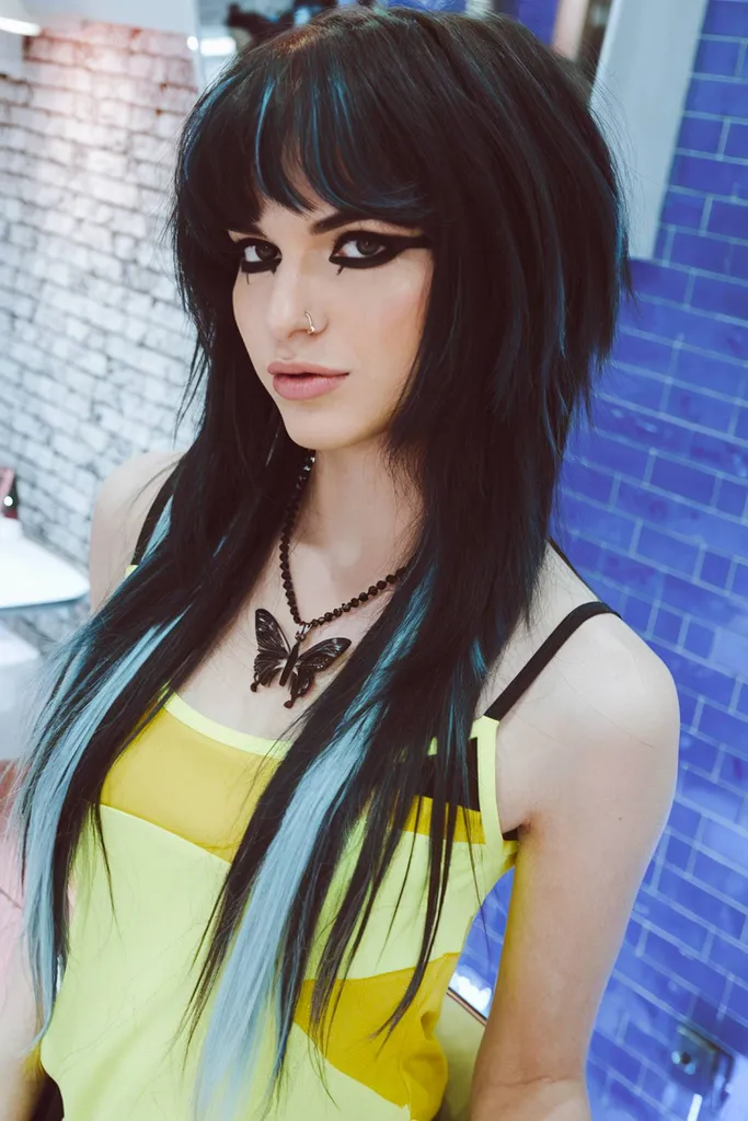 תסרוקת אימו ארוכה בהשראת שנות ה-90 עם שיער שחור ג'ט ופסים כחולים קפואים' title=