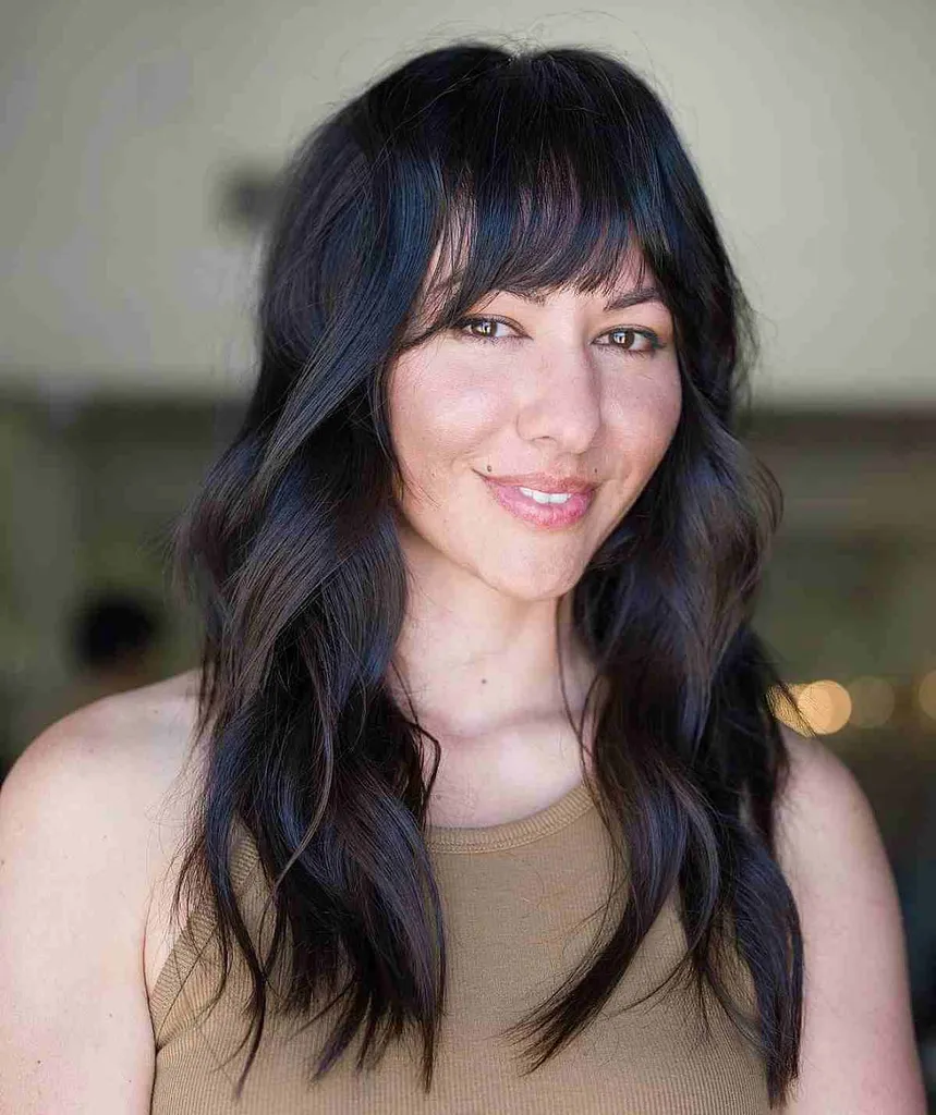 Cabello largo y liso con flequillo para una cara de corazón' title=