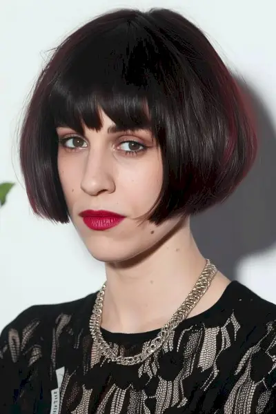 Woman with modern bowl haircut and burgundy color accent