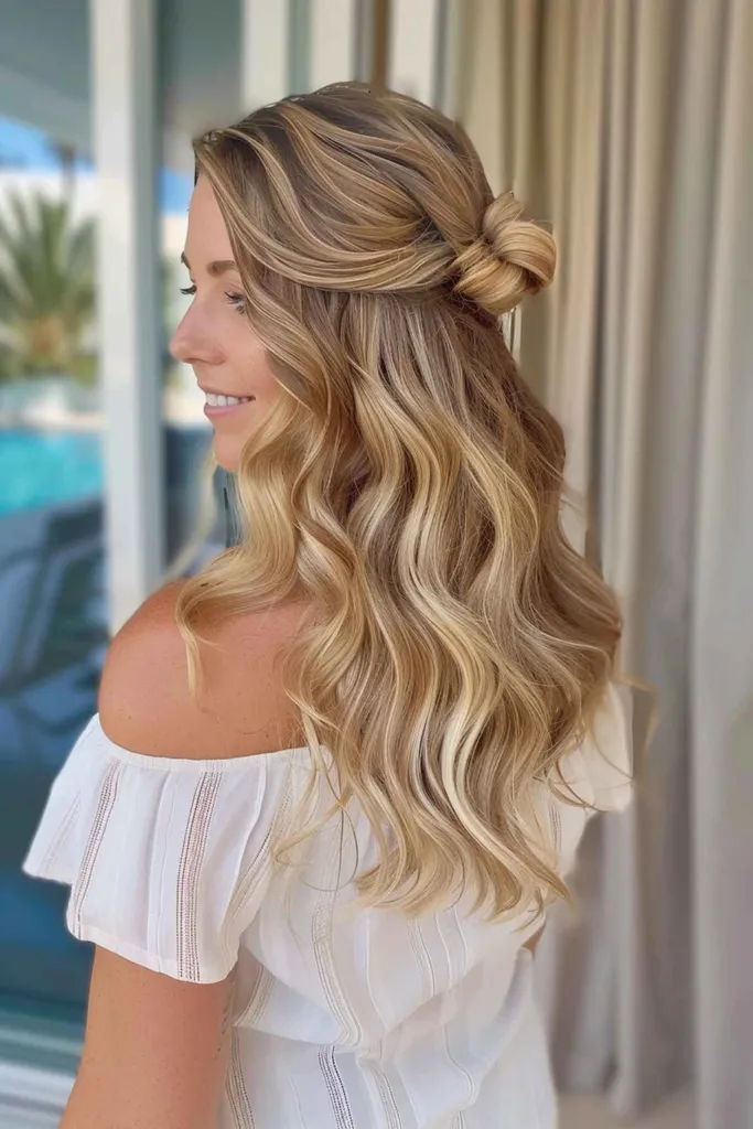 夏にぴったりなハーフアップのウェーブのかかった髪型と結び目の女性' title=