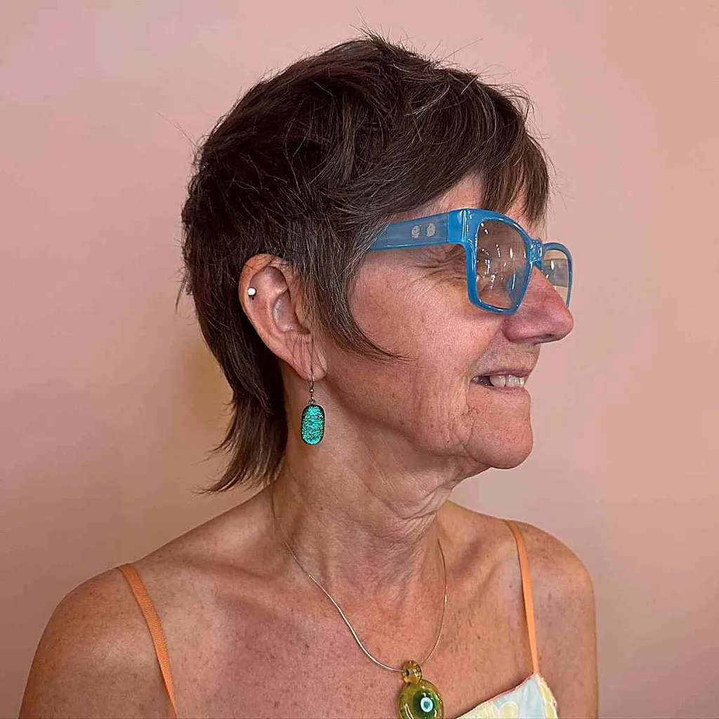 Brünettes Vokuhila-Pixie-Shag-Haar für ältere Frauen über 60 mit Brille' title=