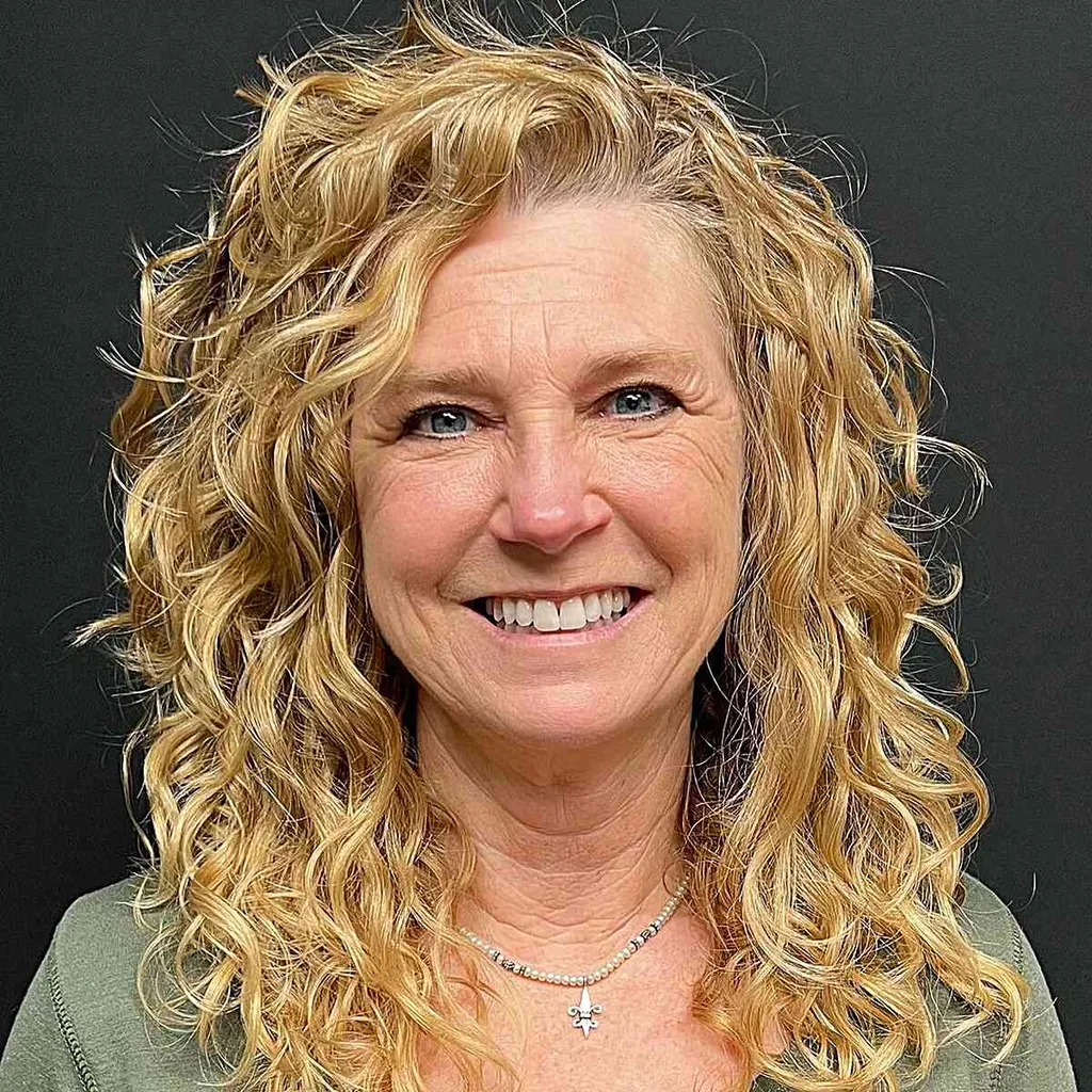 Păr ondulat blond auriu ciufulit, cu o parte laterală până la claviculă' title=