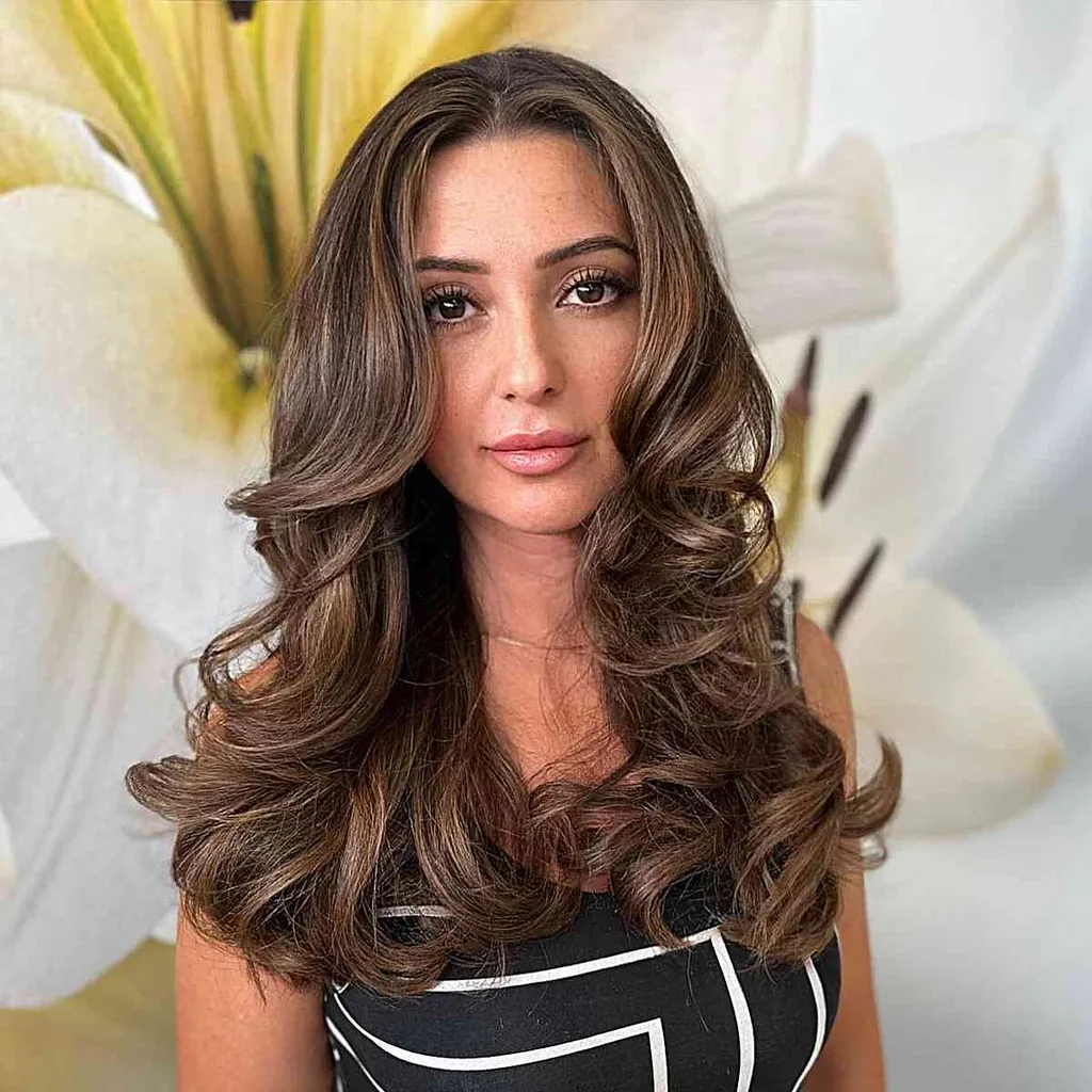 Coafura lungă și ondulată cu partea centrală pentru păr drept' title=