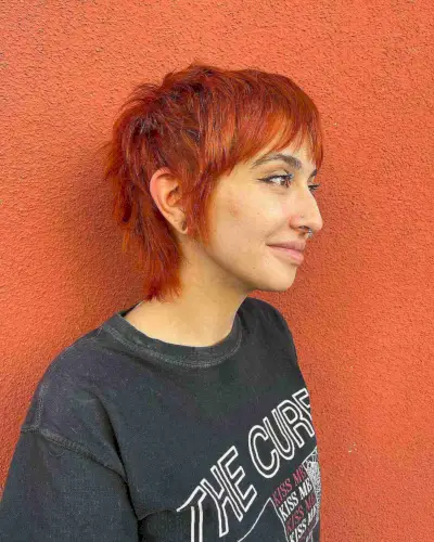 Bold red gender neutral shaggy mullet haircut with choppy bangs
