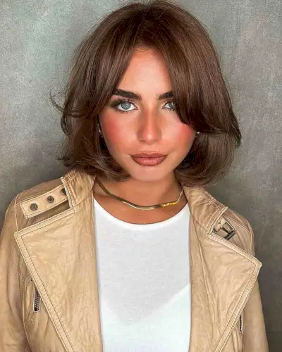 Classic short bob haircut with curtain bangs and voluminous gender neutral style