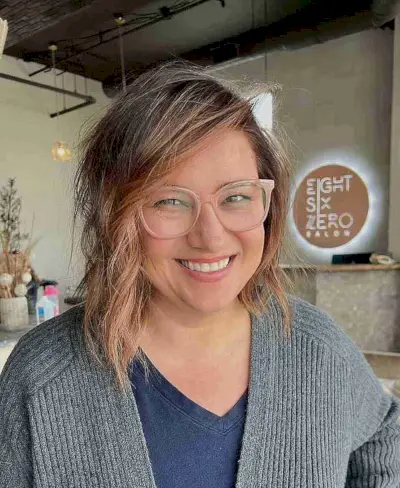 Asymmetrical wavy bob haircut with side part and natural waves gender neutral hair