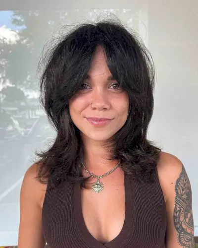 Voluminous shag haircut with soft layers and curtain bangs on medium to thick hair