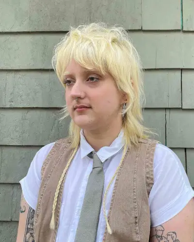 Blonde shaggy mullet with choppy layers and braided accents on medium to thick hair