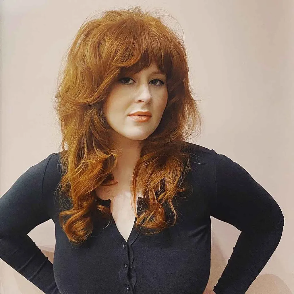 前髪のあるボリュームのあるロングチョッピーヘア。' title=