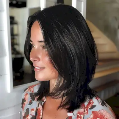 A sleek shoulder-length layered haircut with jet black hair for thin hair