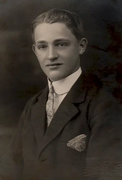 Un portret din anii 1920 arată un bărbat care poartă o coafură pe spate, cu o parte.