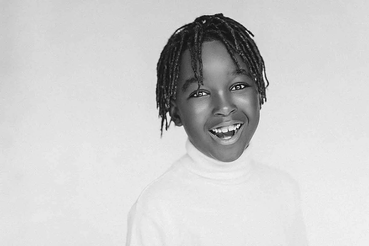 Dreads finos e elegantes em cabelos afro infantis' title=