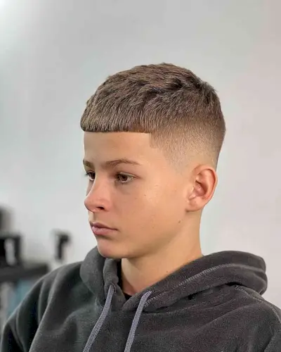 Brushed Forward Fade Cut for Teen Boys with a bald fade on the sides and back