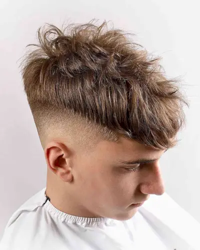 High Fade with a Messy Long Top for Teen Boys with Low Bald Fade