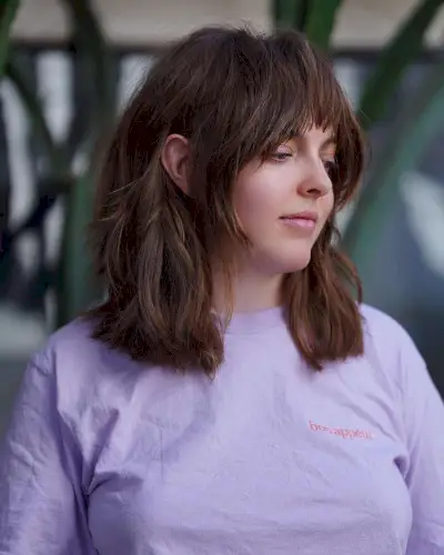 Natural wavy hair with long layers and thick bangs