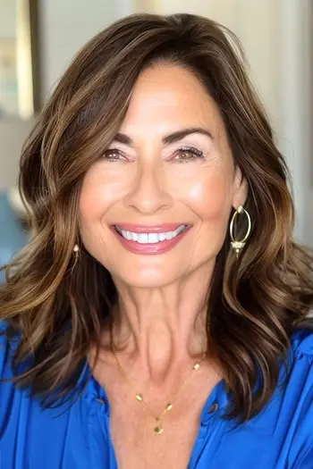 Bløde lag med sidedel frisure på smilende ældre kvinde.