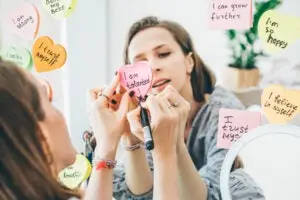 Woman practicing manifestation by writing positive affirmations.