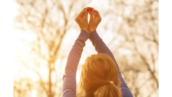 woman looking up at her hands getting in touch with her spirituality