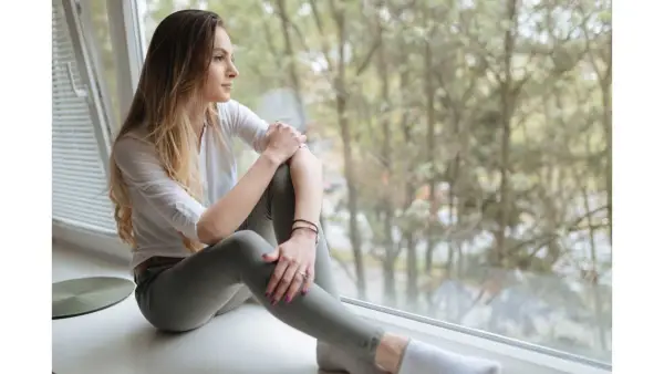 woman sitting on a windowsill by herself