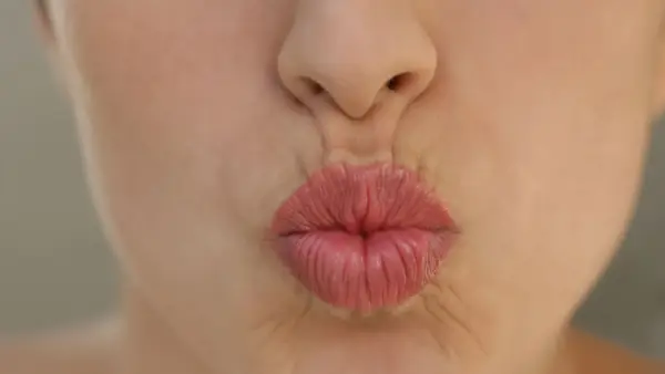 A woman puckers her lips 