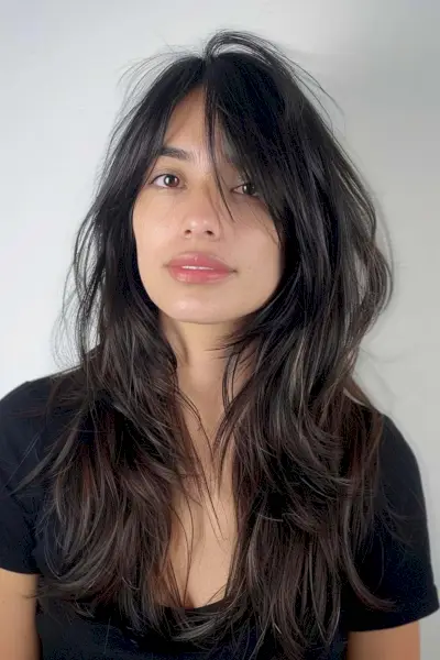 Long natural black wolf haircut with textured layers and bangs