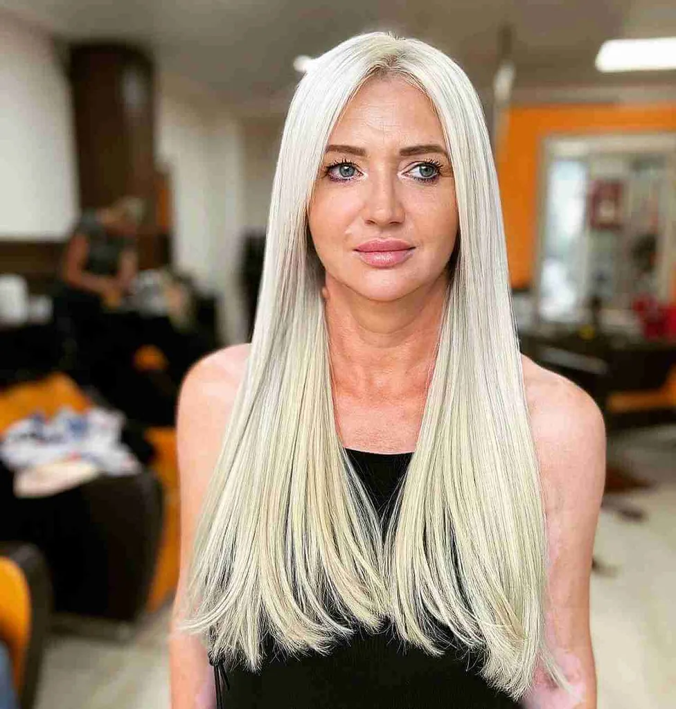 Långt blont rakt trubbigt hår med en mittdel' title=