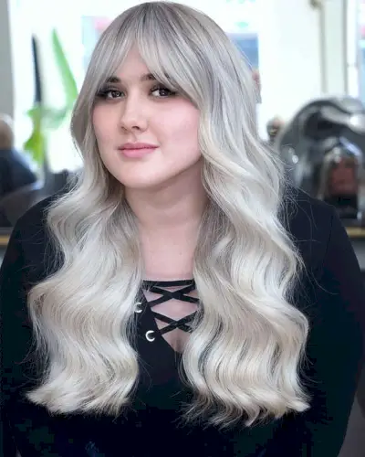 Platinum Wavy Hair with Curtain Bangs for a Fuller Face Shape