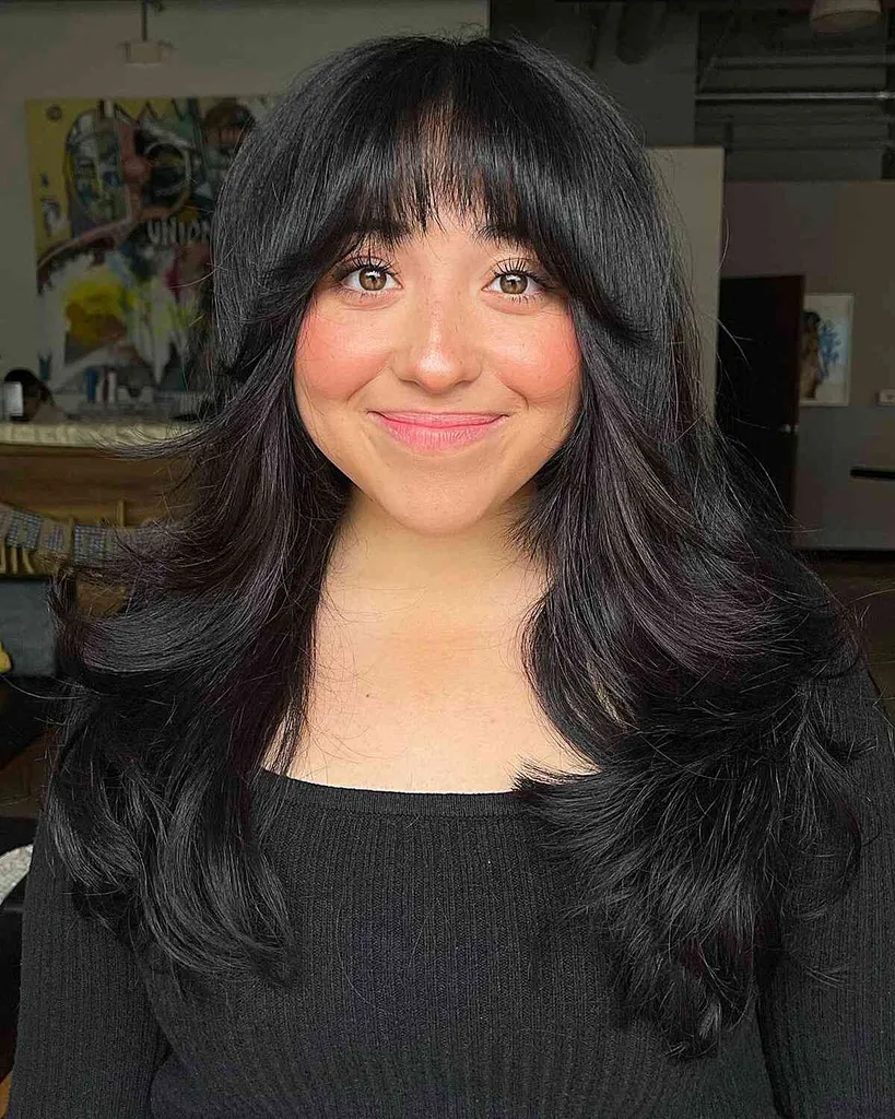 Cabello largo y grueso en capas y flequillo cuello de botella en mujeres con caras más redondas' title=