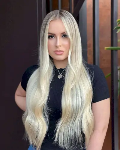 sleek face-framing long layers with dark brunette roots style