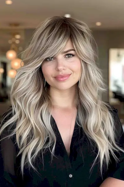 Chic side-swept bangs on long layered blonde hair