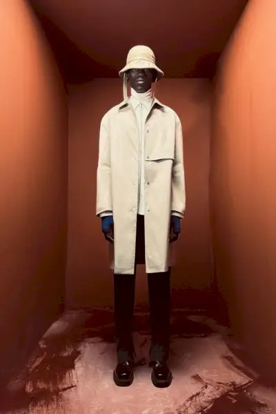 Moustapha Sy dėvi tranšėją su užtrauktuku užsegamais marškiniais, aukšta apykakle ir kostiuminėmis kelnėmis iš 2023 m. „Zara Edition“ pavasario-vasaros kolekcijos.