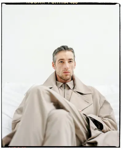 Šūpojot lielajā tranšejā, Džoels Fremptons modelē jaunākos Adolfo Domingesa vīriešu apģērbus.