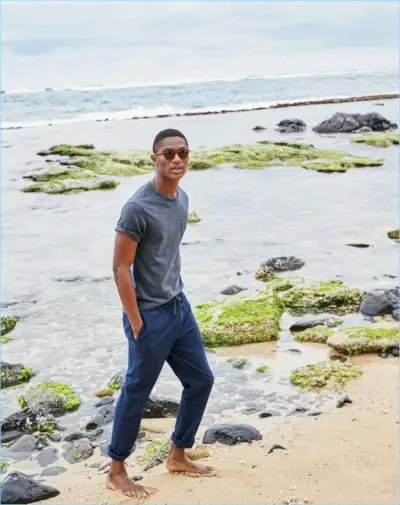 ビーチに向かうハミッド・オニフェイドは、J.Crew ガーメントダイ T シャツ 39.50 ドルとシアサッカーのドローストリング パンツ 75 ドルを着ています。